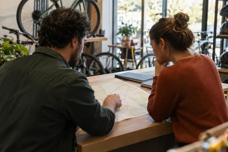 Illustrative discussion over an unlabelled paper route sketch at a counter.