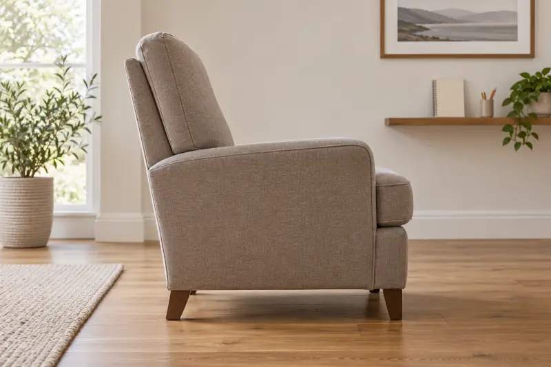 Illustrative side view of an empty upholstered chair on a clear floor.