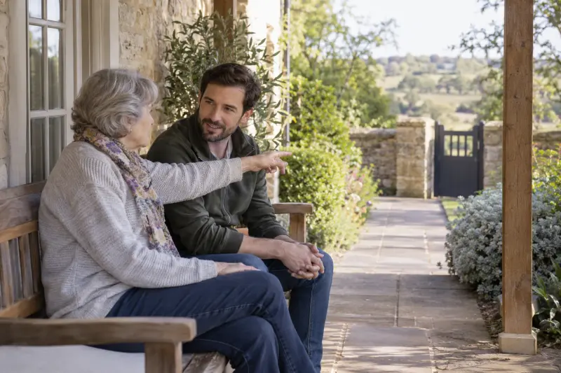 Illustrative scene of two adults on a garden bench discussing a path toward a gate.