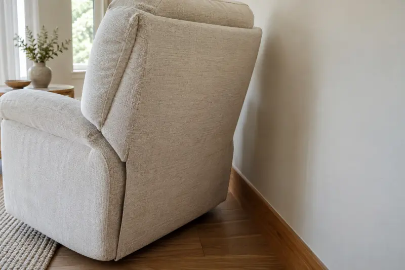 Illustrative photograph of an upholstered chair back beside a plain wall and wooden skirting.
